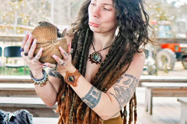 a woman holding an armadillo